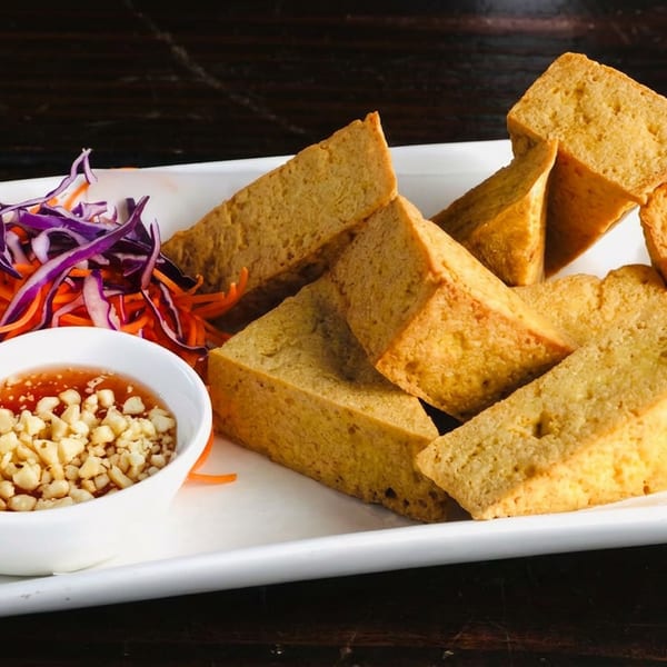 Crispy fried tofu triangles with shredded carrots, purple cabbage, and peanut dipping sauce.